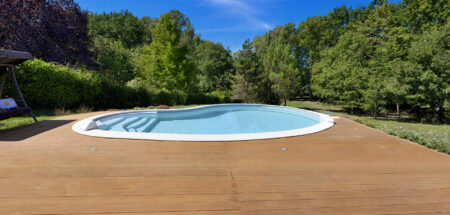 Piscine haricot avec escalier intérieur sur terrasse en bois