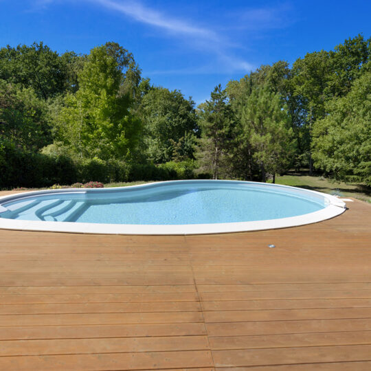 Piscine haricot avec escalier intérieur sur terrasse en bois