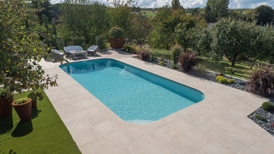 Grande piscine rectangulaire sur plage en dalles de béton