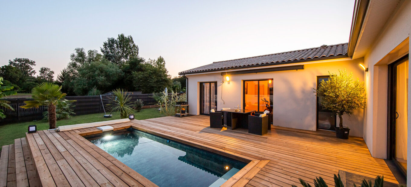 Narrow swimming pool in small garden at night