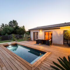 Narrow swimming pool in small garden at night