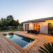 Narrow swimming pool in small garden at night