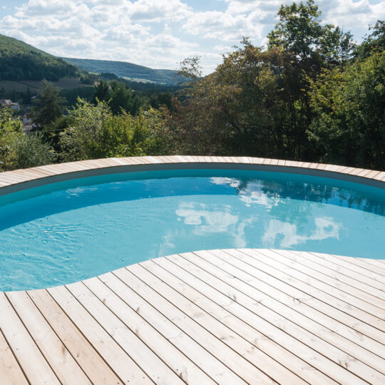 Piscine Waterair en forme de haricot sur terrasse en bois avec belle vue
