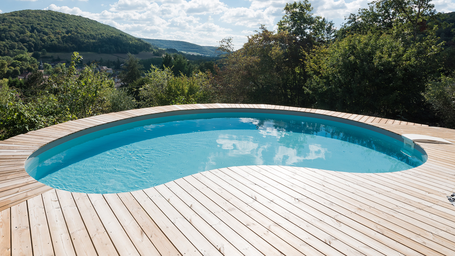 Piscine Waterair en forme de haricot sur terrasse en bois avec belle vue