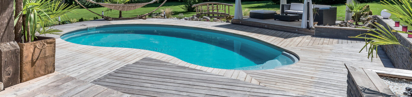 Piscine en forme de haricot avec escalier entrant sur terrasse en bois