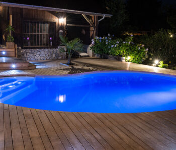 Superbe piscine Waterair en forme de haricot éclairée par des projecteurs