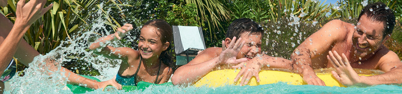 Personnes s'amusant en famille dans leur piscine