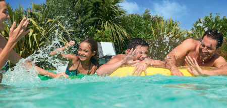 Personnes s'amusant en famille dans leur piscine