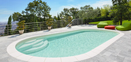 Piscine ovale Elsa dans un jardin avec terrasse en dalles de béton