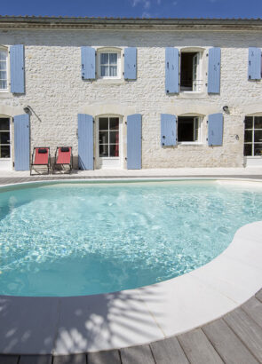 Piscine forme libre Emma devant une maison avec terrasse