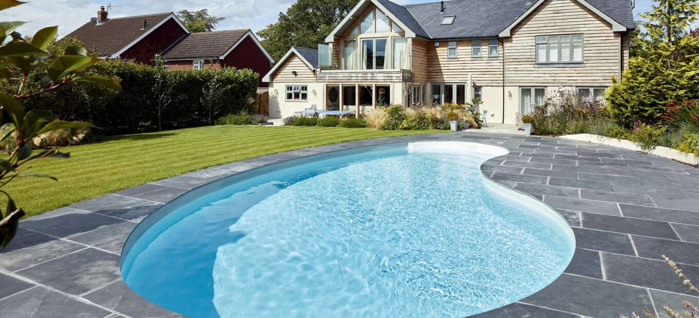 instalar una piscina enterrada riñón con casa moderna
