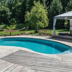 instalar una piscina riñón con tarima de madera exterior