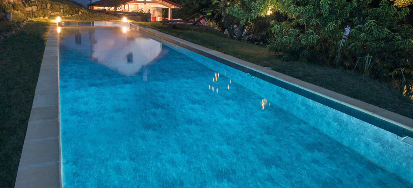 piscina rectangular grande con terraza de madera