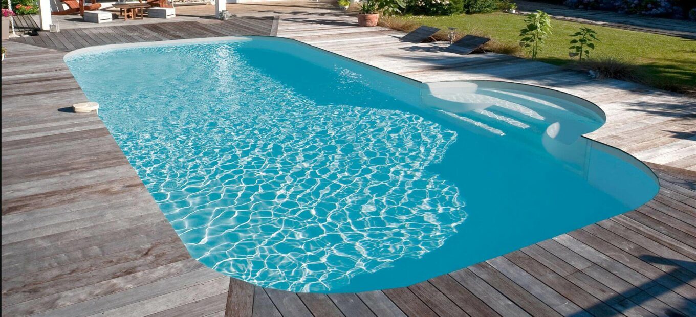 Piscina rettangolare con scale e area a bordo vasca in legno