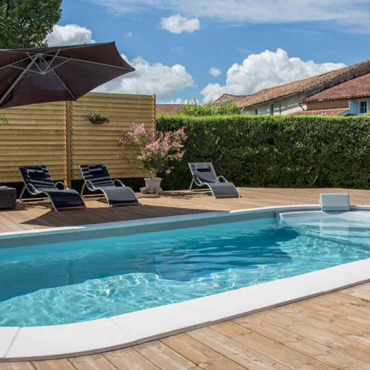 Piscine de forme libre Luna avec margelles et plage en bois