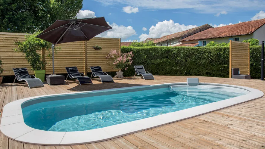 Piscine de forme libre Luna avec margelles et plage en bois