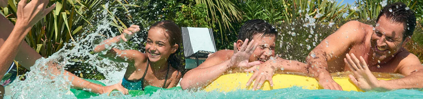 Personnes s'amusant en famille dans leur piscine