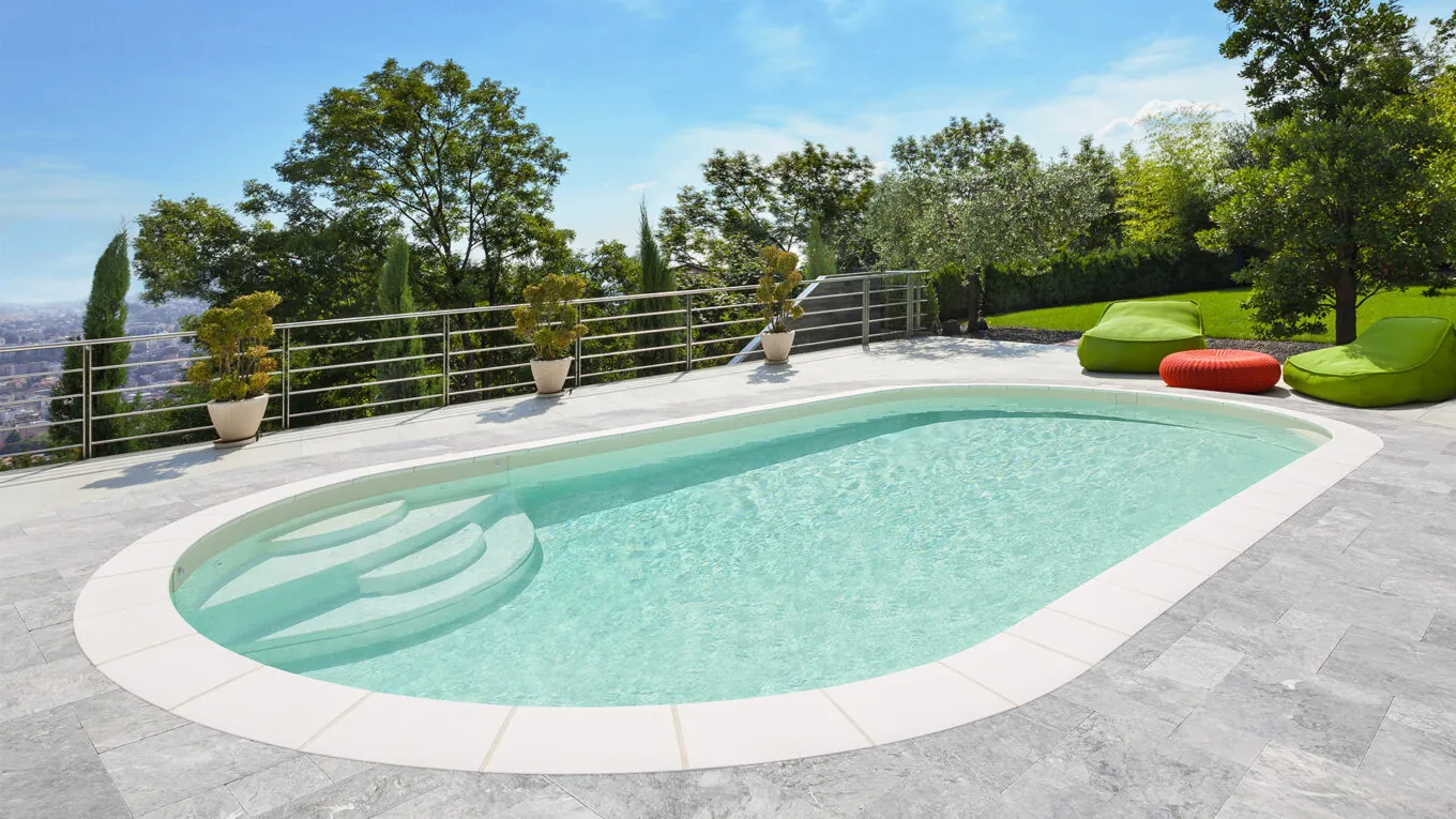 Piscine ovale Elsa dans un jardin avec terrasse en dalles de béton