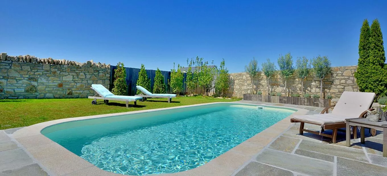 idea de decoración de jardin y terraza de piedra con piscina rectangular